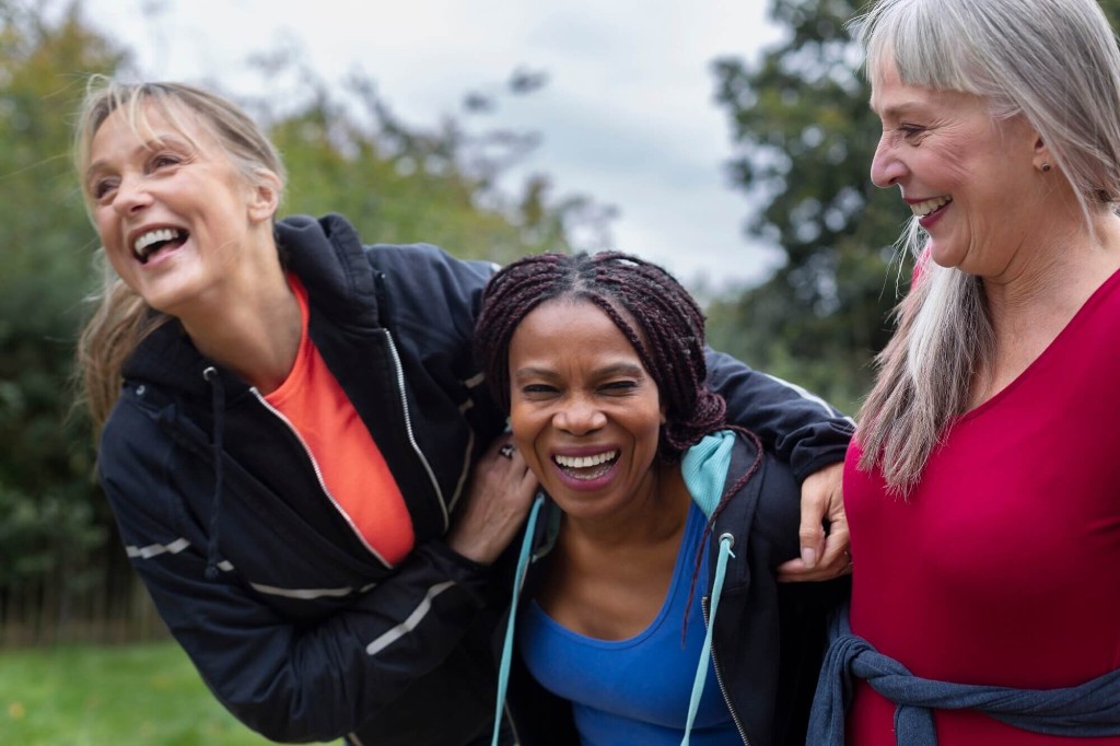 Three women laughing outdoors