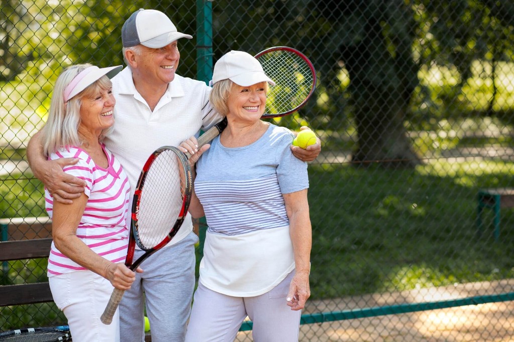 Three people with tennis rackets on a court